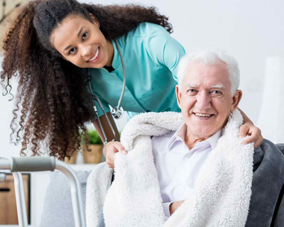 a nurse and a senior man smiling