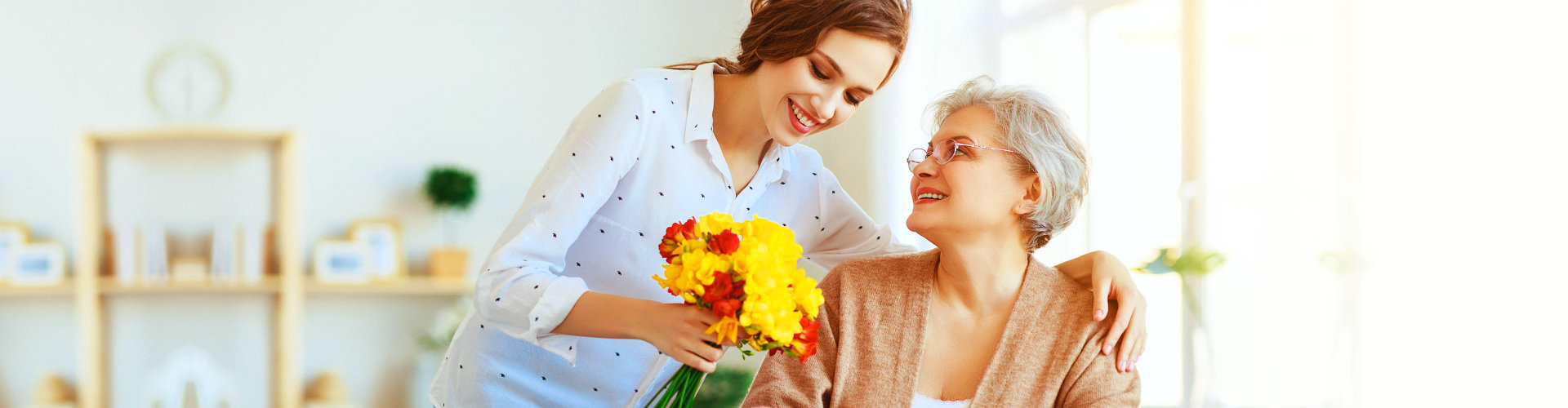 caregiver giving flowers to a senior
