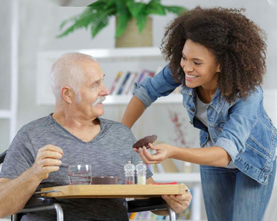 a caregiver giving a senior man his medicine