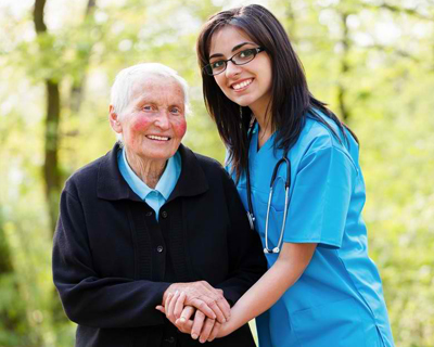 a nurse and a senior woman taking a walk outside