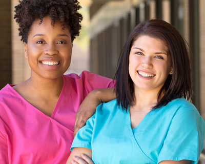 two caregivers smiling