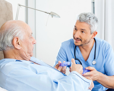 a nurse giving medicine to a senior man