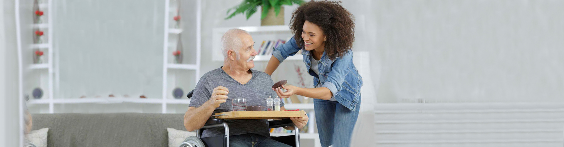 a caregiver giving a senior man his medicine