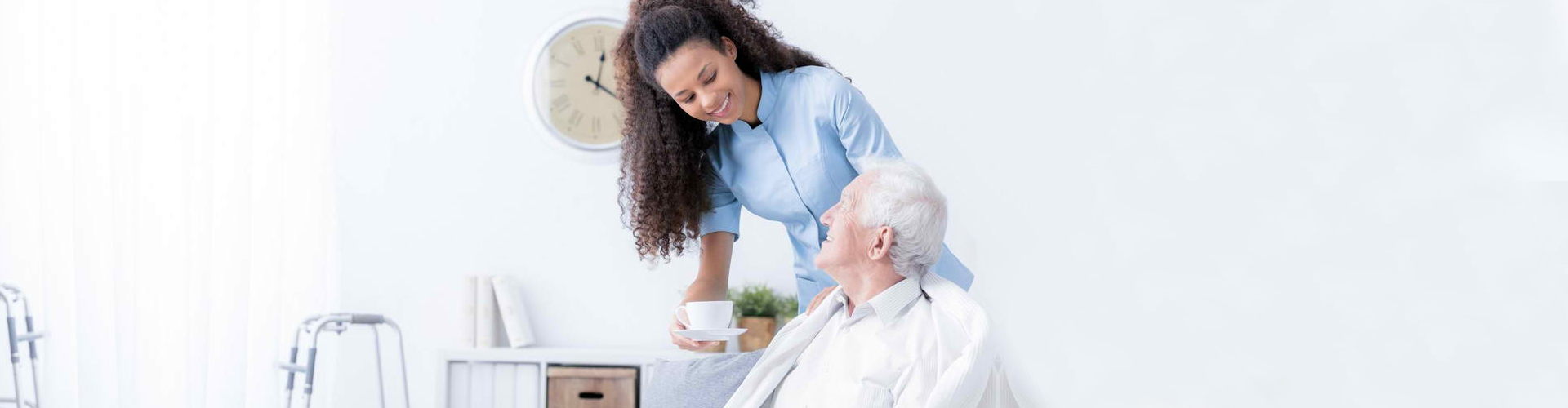 a caregiver giving a senior man his coffee