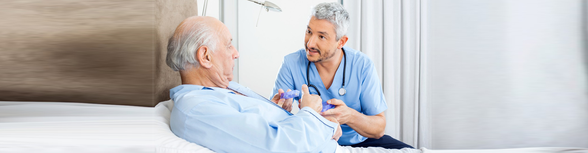 a nurse giving medicine to a senior man